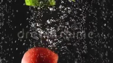 黄瓜和番茄片落入水中的黑色背景。 新鲜蔬菜在水中有气泡。 有机有机